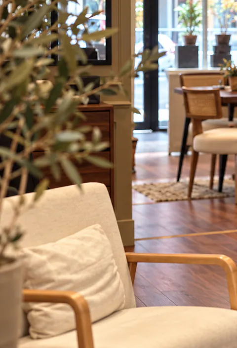 Fauteuil clair et plantes dans un espace de travail chaleureux au parquet de bois