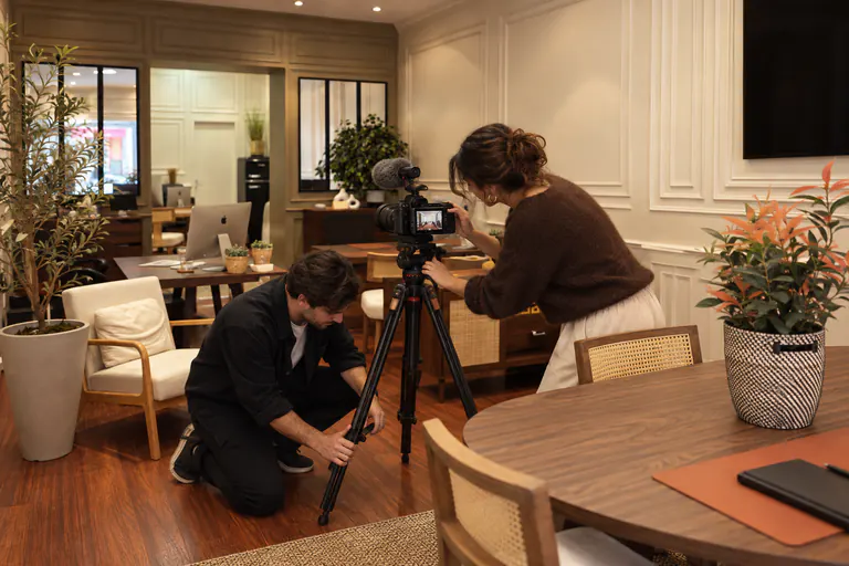 Un vidéaste installe une caméra sur trépied avant un tournage