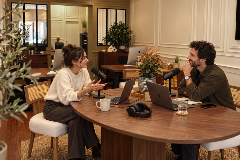 Deux personnes enregistrent une interview audio avec des micros sur une table