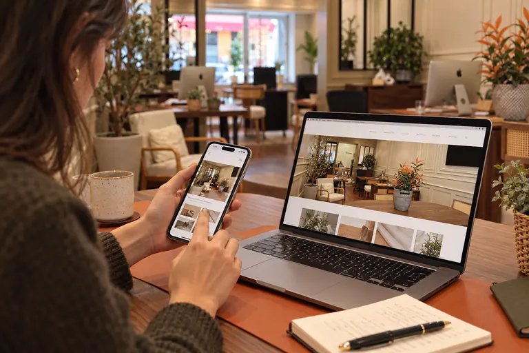 Un site web affiché sur ordinateur et sur smartphone, tenu en main