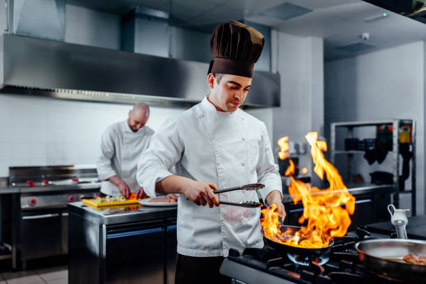 Shot of two young chefs in the kitchen preparing food agence web cuisiniste à Lyon
