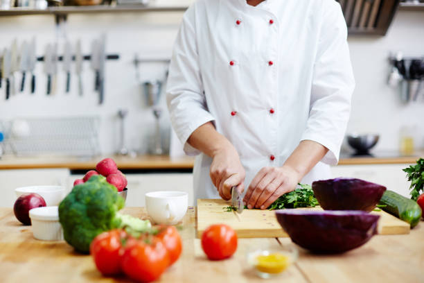 Chef of restaurant cooking fresh vegetable salad from green and red vegs agence web cuisiniste à Lyon
