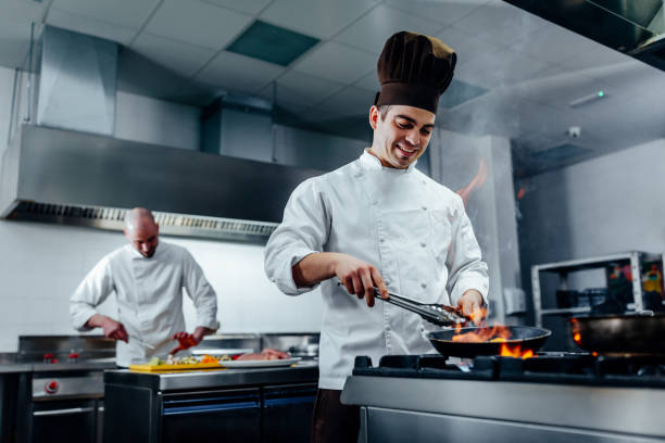Shot of two young chefs in the kitchen preparing food services web cuisiniste à Lyon