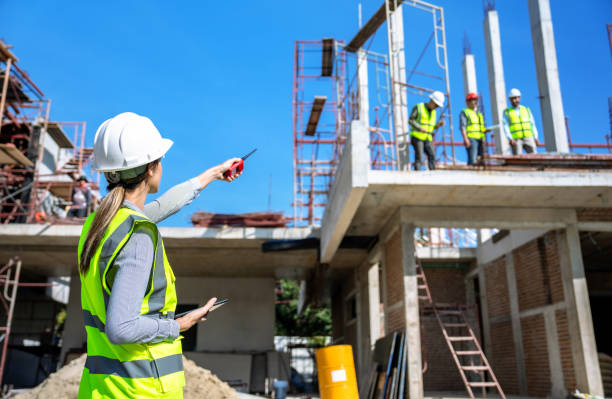 The engineer talks to the contractor to supervise and plan the work. agence web préférée des entrepreneurs en construction à Lyon