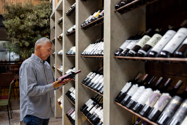 Latin American man buying a bottle of wine at a cellar agence web boulangers Lyon