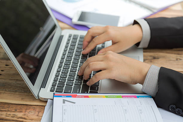 Closeup of business woman hand typing on laptop keyboard Agence Web Vienne