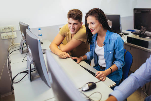 College students sitting in a classroom, using computers during class. agence web La Mulatière