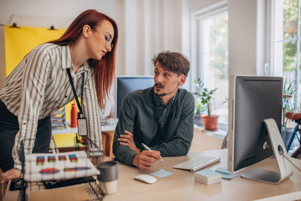 Two people, woman and man working together in modern office. agence web à Sérézin-du-Rhône