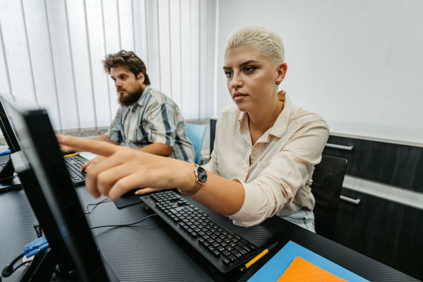 Two students sitting in a programing class and learning