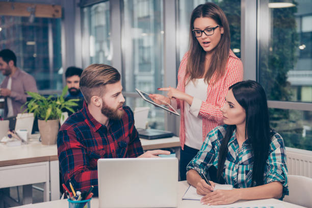 Young woman giving advices to executive managers about project En tant qu'agence web Lentilly expérimentée, nous comprenons l'importance d'une présence